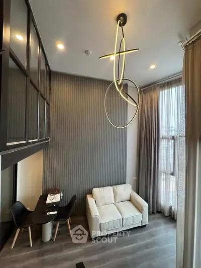 Modern living room with high ceiling and stylish lighting in a contemporary apartment.