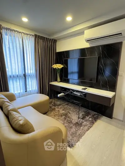 Modern living room with sleek design, featuring a cozy sofa, large TV, and elegant decor.