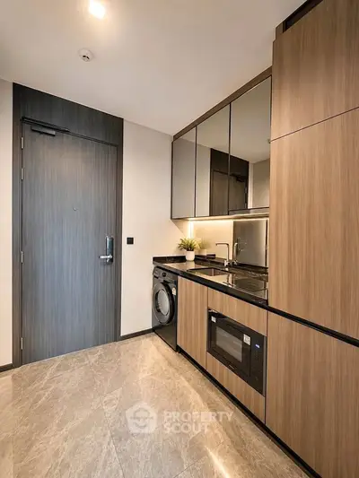 Modern kitchen with sleek cabinets, built-in appliances, and elegant flooring in a compact layout.