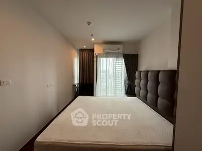 Spacious bedroom with large window and modern decor in urban apartment