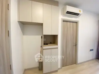 Modern minimalist interior with sleek cabinetry and air conditioning unit.
