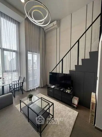 Modern loft-style living room with high ceilings and stylish lighting in a chic apartment.