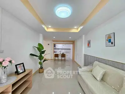 Modern living room with elegant decor and open layout leading to a stylish kitchen.