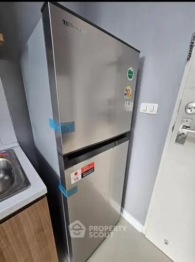 Modern kitchen with sleek Toshiba refrigerator and stylish cabinetry.