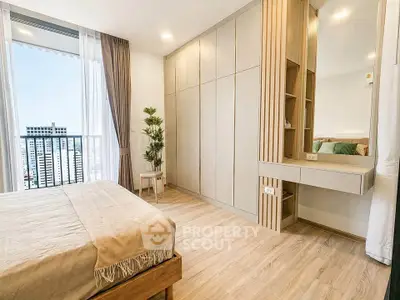 Modern bedroom with large window and built-in wardrobe in high-rise apartment