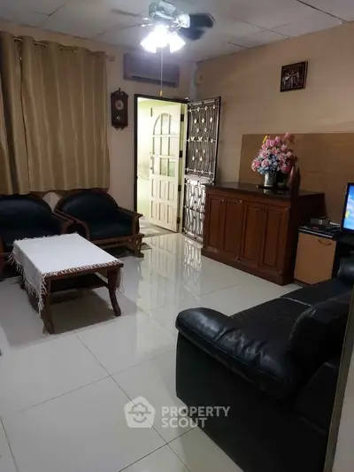 Cozy living room with elegant furniture and polished tile flooring, perfect for relaxation and entertainment.
