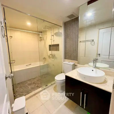 Modern bathroom with glass shower and sleek fixtures in a contemporary apartment.