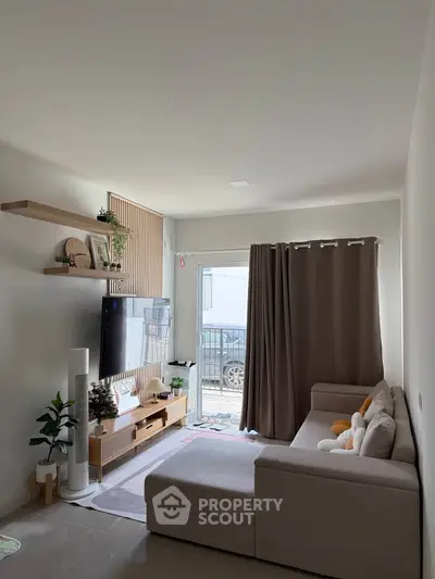 Modern living room with cozy sectional sofa and wall-mounted TV, featuring natural light and minimalist decor.