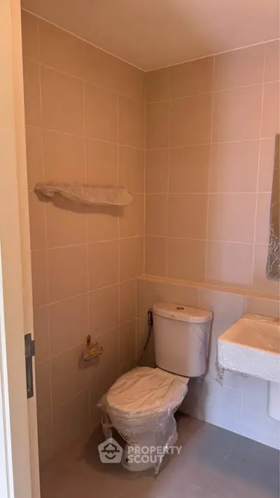 Modern bathroom with tiled walls and new fixtures, ready for customization.