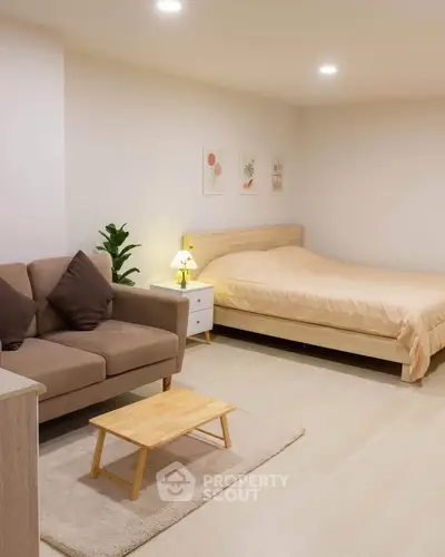 Spacious studio apartment with cozy bed and stylish sofa in modern decor.