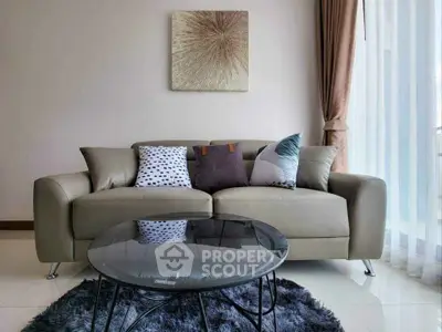Stylish living room with modern sofa, chic pillows, and elegant glass coffee table on plush rug.