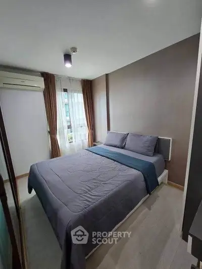 Cozy bedroom with modern decor and natural light in a stylish apartment.