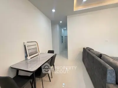 Modern living room with sleek furniture and minimalist decor, featuring a cozy dining area and stylish sofa.