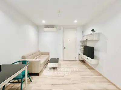 Modern living room with sleek furniture and minimalist design, featuring a cozy sofa and wall-mounted TV.