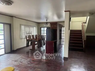 Spacious open-plan living area with wooden floors and natural light.