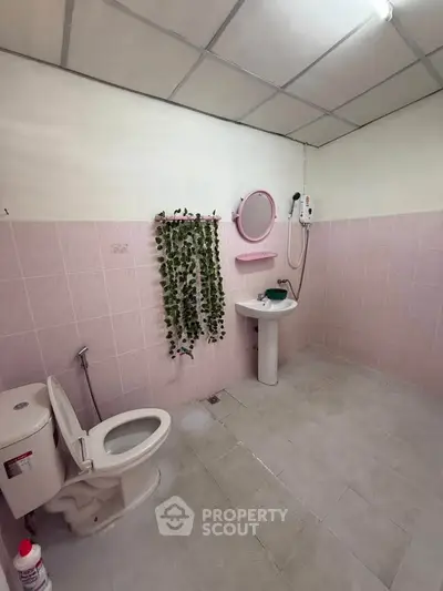 Spacious bathroom with pink tiles and modern fixtures