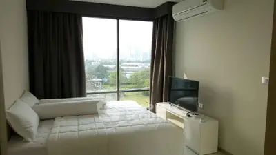 Modern bedroom with large window and city view, featuring a cozy bed and sleek TV setup.