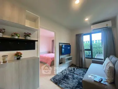 Modern living room with cozy sofa, wall-mounted TV, and large window view