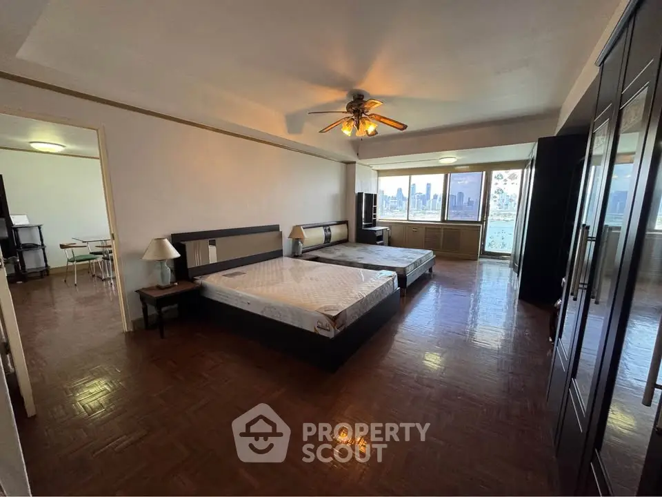 Spacious bedroom with city view and elegant wooden flooring