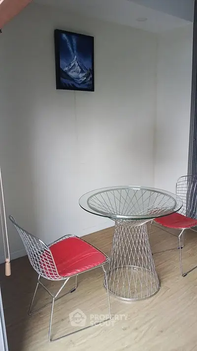 Modern minimalist dining area with wire chairs and glass table, perfect for cozy meals.