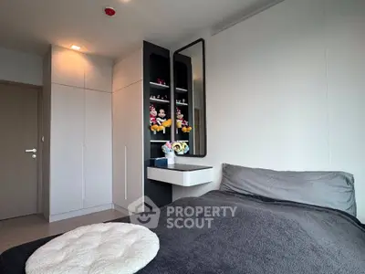 Modern bedroom with sleek storage and cozy bedding in a stylish apartment.