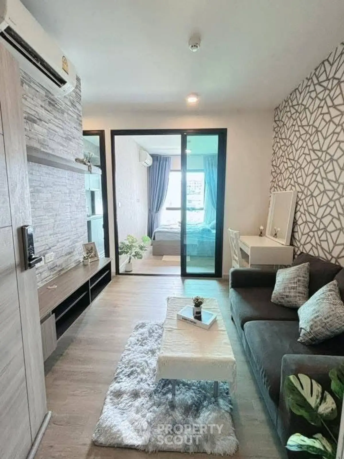 Modern living room with stylish decor and view into cozy bedroom