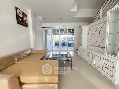 Spacious living room with modern decor and large glass doors leading to a balcony.