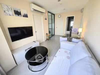 Modern living room with sleek furniture and wall-mounted TV in a cozy apartment.