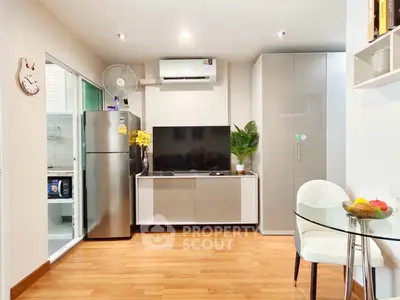 Modern living room with sleek TV unit, air conditioning, and adjacent kitchen area in stylish apartment.