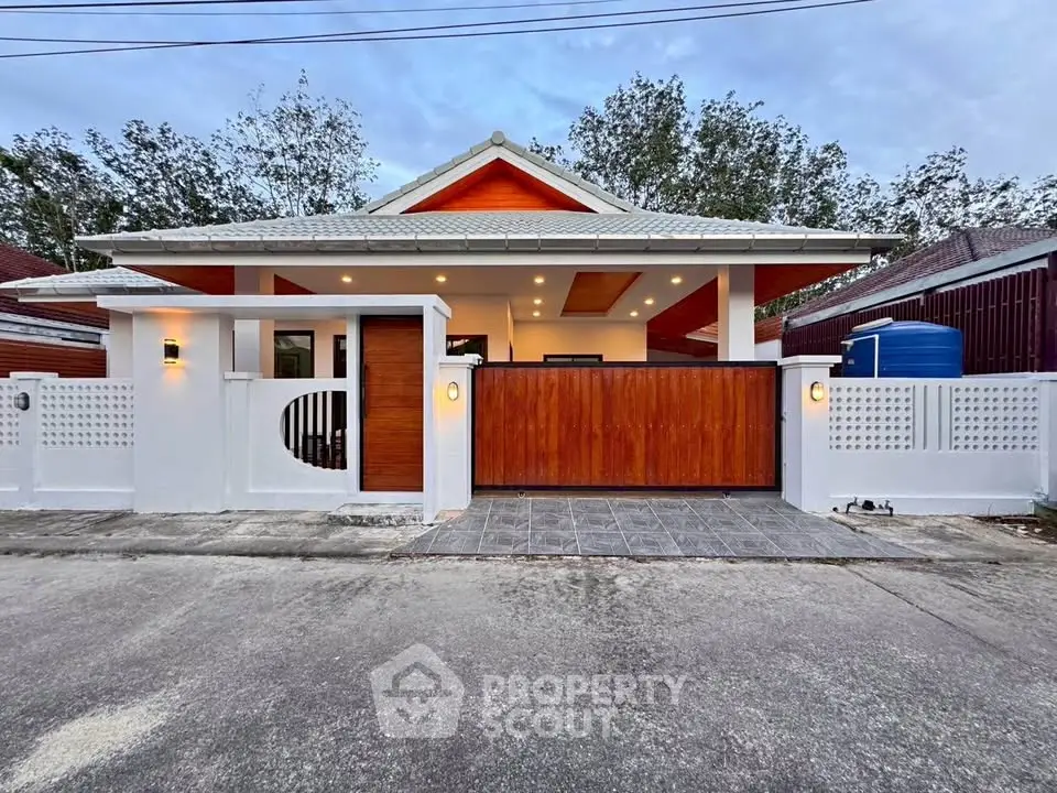 Charming modern house with stylish wooden gate and white fence, perfect for serene living.