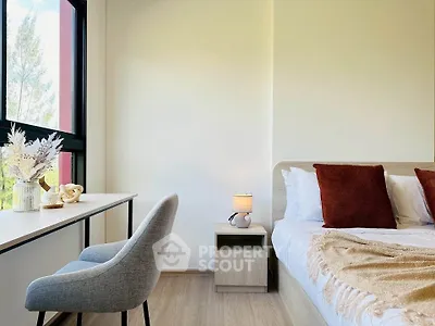 Modern bedroom with stylish decor and natural light, featuring a cozy bed and a sleek desk area.