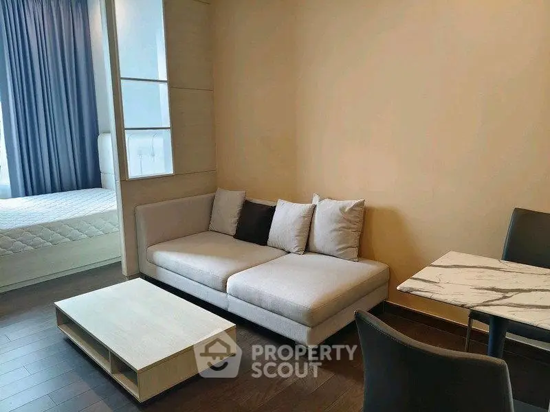 Modern living room with cozy sofa and stylish dining area in open layout apartment.