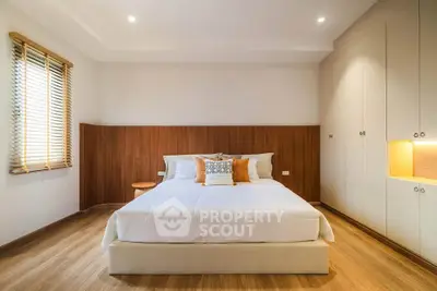 Spacious modern bedroom with wooden accents and built-in storage