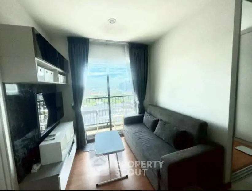 Modern living room with sleek furniture and city view from large window.