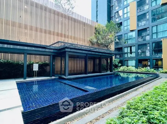 Luxurious modern apartment complex with stunning outdoor pool and lush greenery