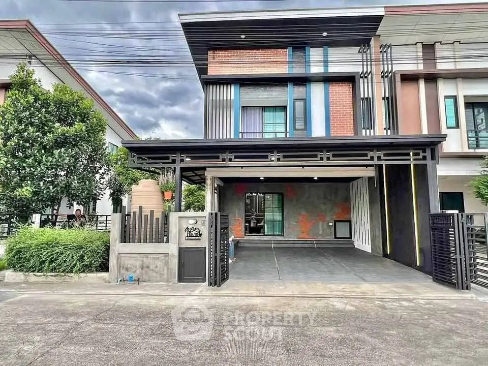 Modern two-story house with sleek design and spacious driveway in a suburban neighborhood.