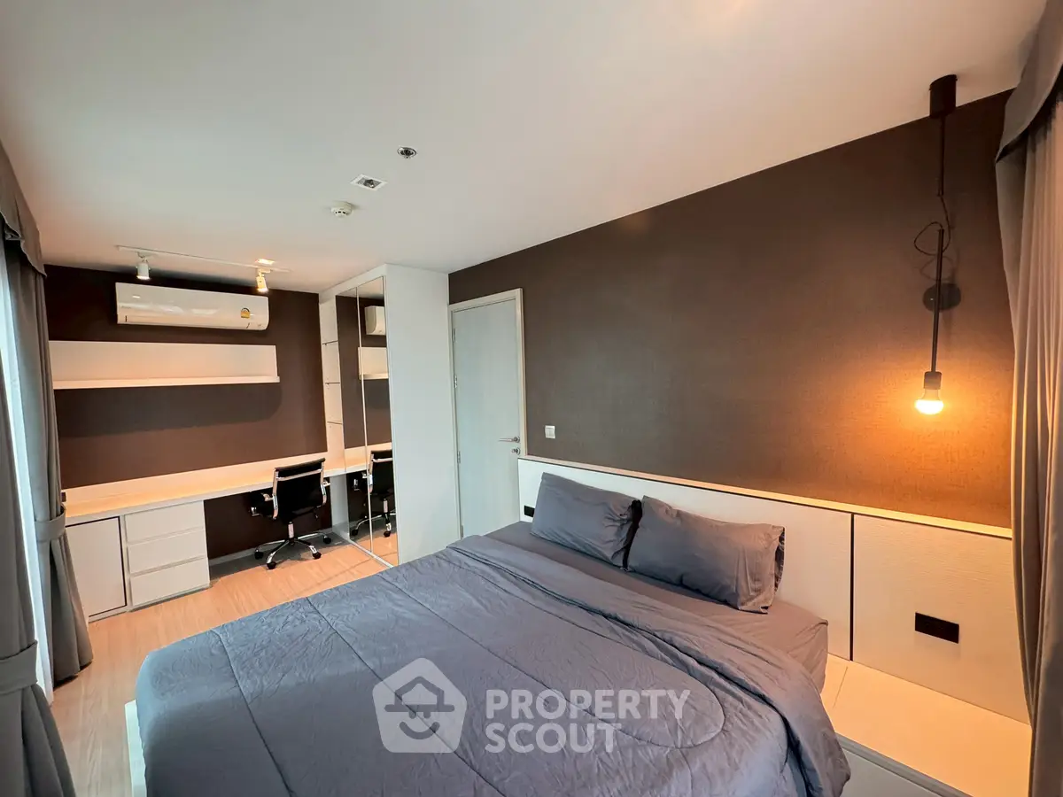 Modern bedroom with cozy lighting and stylish workspace in a contemporary apartment.
