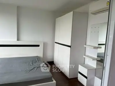 Modern minimalist bedroom with sleek white furniture and wooden flooring