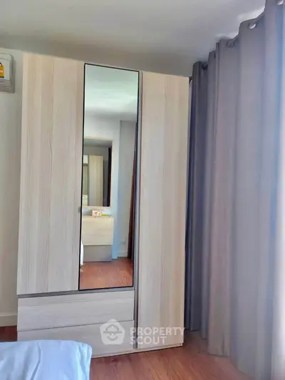 Modern bedroom with sleek wardrobe and floor-to-ceiling curtains