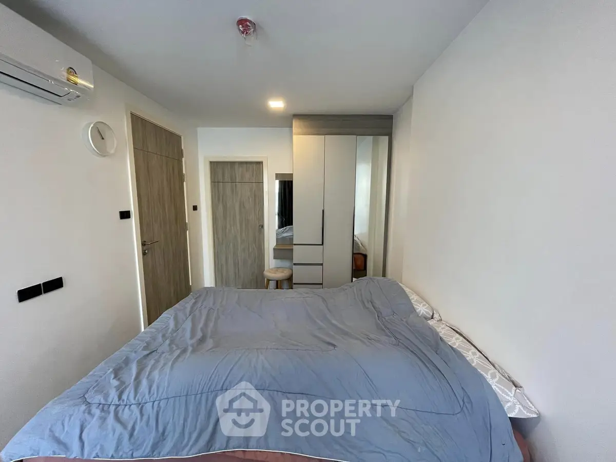 Modern bedroom with sleek design and ample storage in a contemporary apartment.