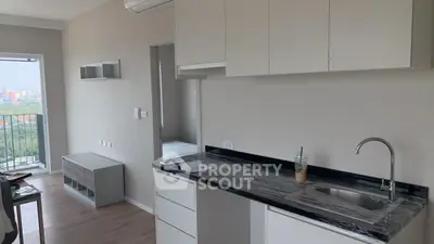 Modern apartment kitchen with sleek cabinets and balcony view