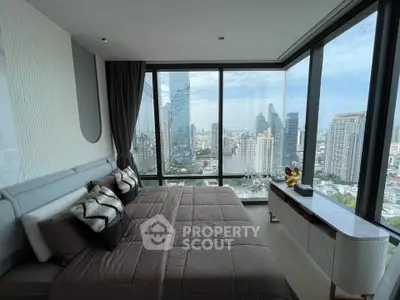 Luxurious bedroom with panoramic city views in a modern high-rise apartment.