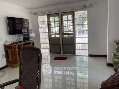 Spacious living room with glossy floors and large windows for natural light.