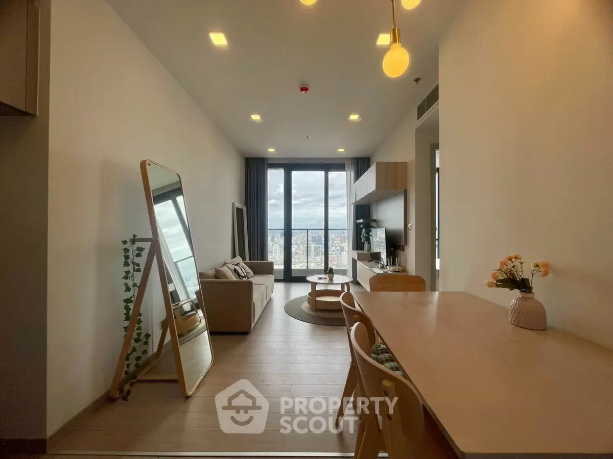 Modern living room with city view, stylish decor, and ample natural light.