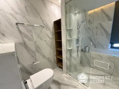 Luxurious modern bathroom with marble tiles and glass shower enclosure