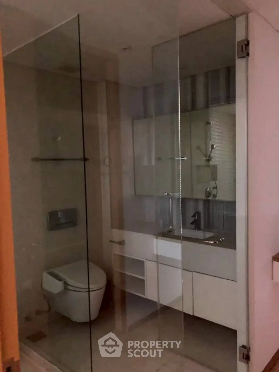 Modern bathroom with glass shower enclosure and sleek fixtures