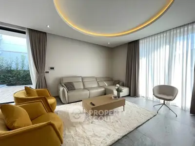 Modern living room with stylish furniture and elegant lighting, featuring a cozy seating area and large windows.
