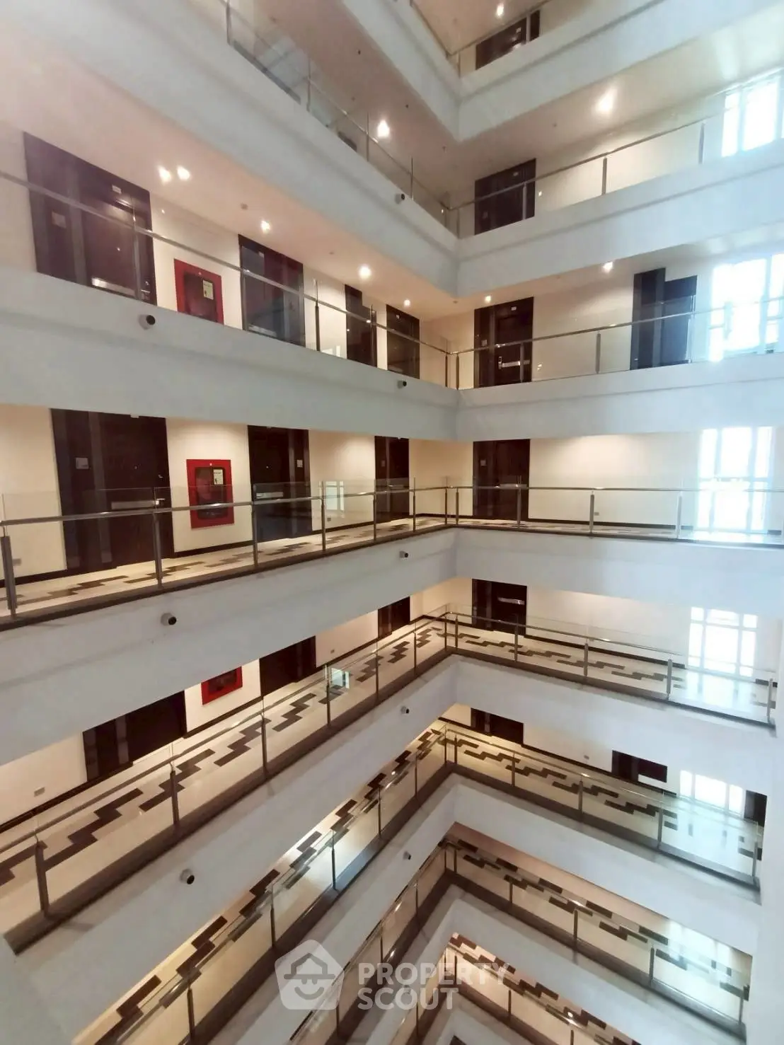 Modern multi-story building interior with glass railings and bright lighting