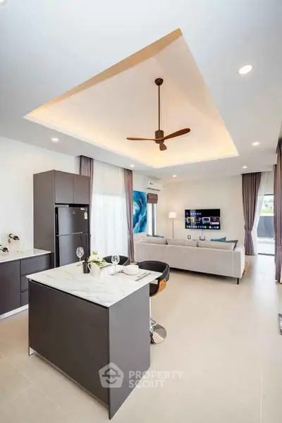 Modern open-plan living room and kitchen with stylish decor and ceiling fan