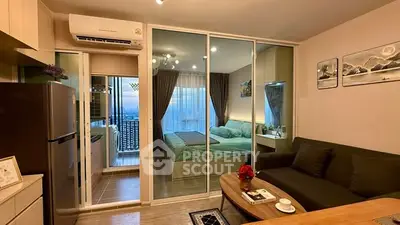 Modern apartment interior with open layout, featuring living room, kitchen, and bedroom with balcony view.